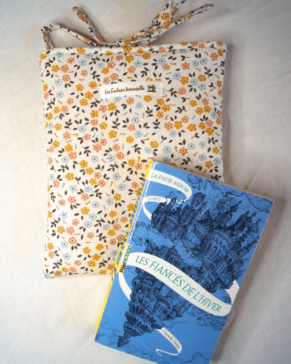Pochette livre de poche ou liseuse en coton fleuri. Fermeture par des liens à nouer.