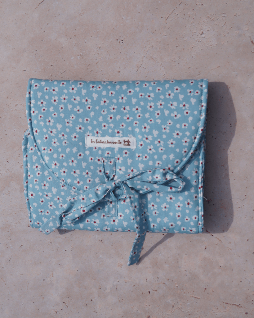 Pochette à bijoux bleue avec des fleurs blanches et rouges