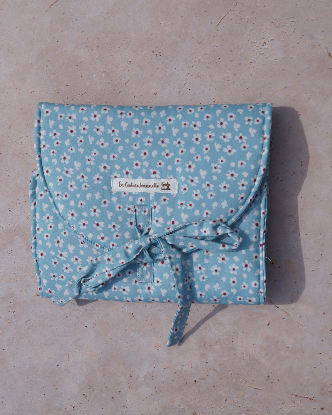 Pochette à bijoux bleue avec des fleurs blanches et rouges
