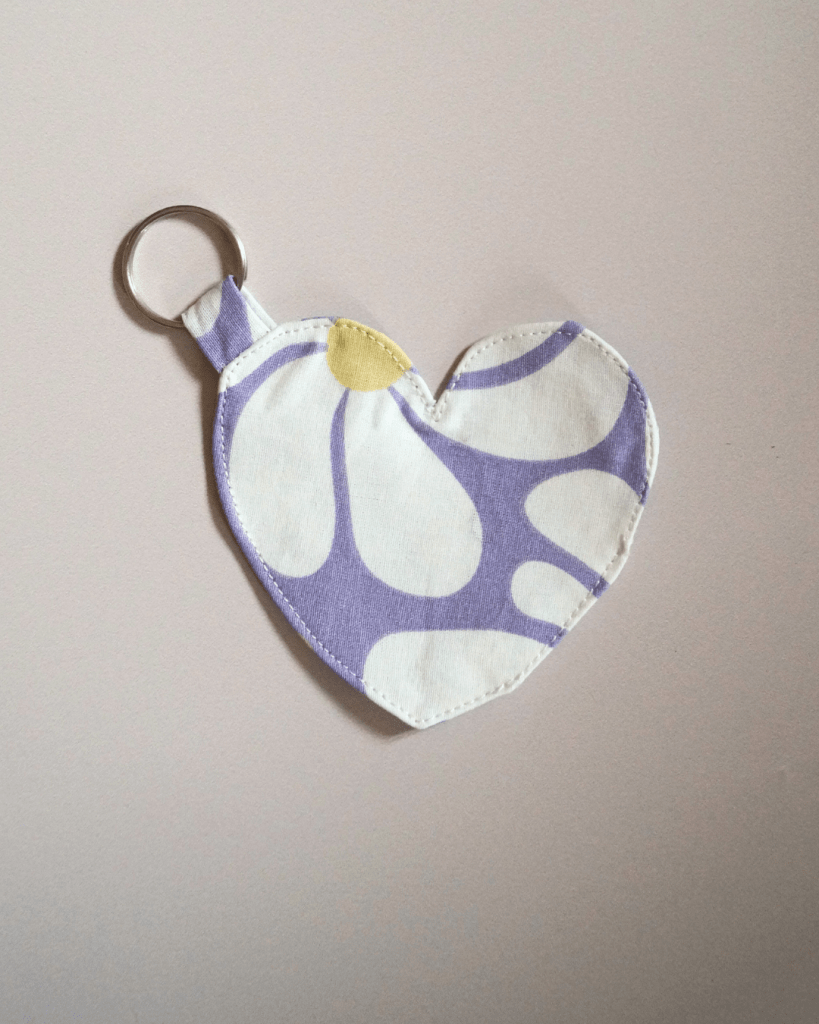 Porte clés en forme de coeur, fond lilas fleurs blanches et jaunes